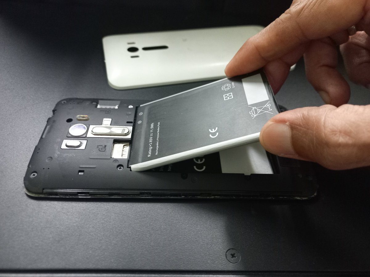 Tekniker byter ut ett skadat mobilbatteri